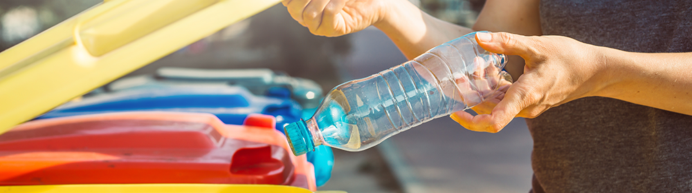 Plastikflasche wird in gelbe Recyclingtonne entsorgt – Mülltrennung und Kunststoff-Recycling im Haushalt für nachhaltige Abfallentsorgung